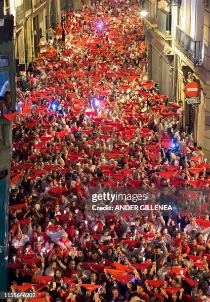 Revellers raise red scarves and candles as they sing the song 'Pobre de Mi', marking the end of the San Fermin festival in Pamplona, northern Spain...