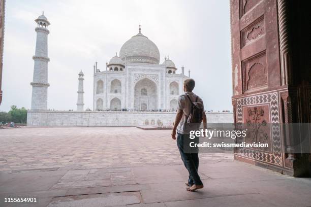 joven contemplando el famoso taj mahal al atardecer - agra fotografías e imágenes de stock