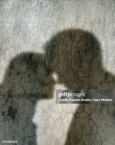 stockillustraties, clipart, cartoons en iconen met concept image of shadows on a distressed wall of a couple embracing depicting a fragile relationship - relatieproblemen