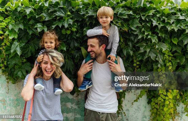 portrait of happy family outdoors - baby attitude stock pictures, royalty-free photos & images