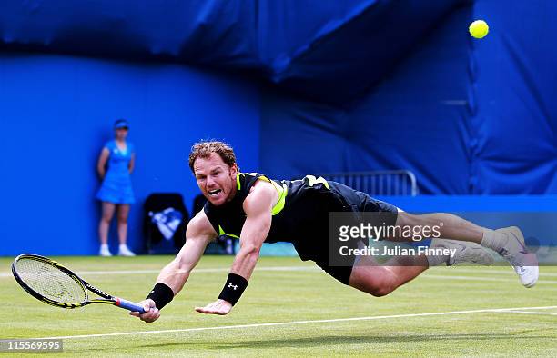 Michael Russell of the United States dives to hit a return shot during his Men's Singles second round match against Janko Tipsarevic of Serbia on day...