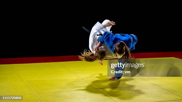 weibliche judoka wirft ihren partner auf die tatami-matte - tatami matte stock-fotos und bilder