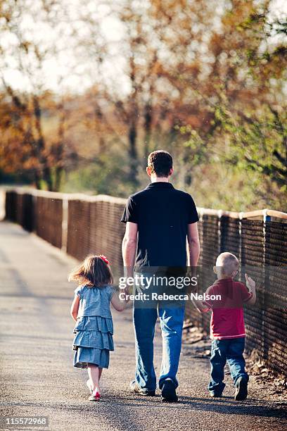 uncle walking across bridge with niece and nephew - uncle nephew stock pictures, royalty-free photos & images