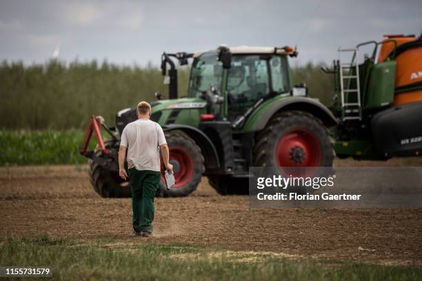 Young farmer walks to a tractor on June 28, 2019 in Koellitsch, Germany.