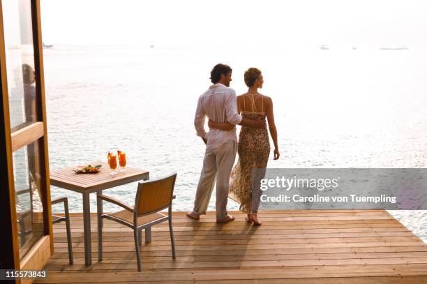 couple on deck of restaurant looking out to sea - boat deck stock pictures, royalty-free photos & images