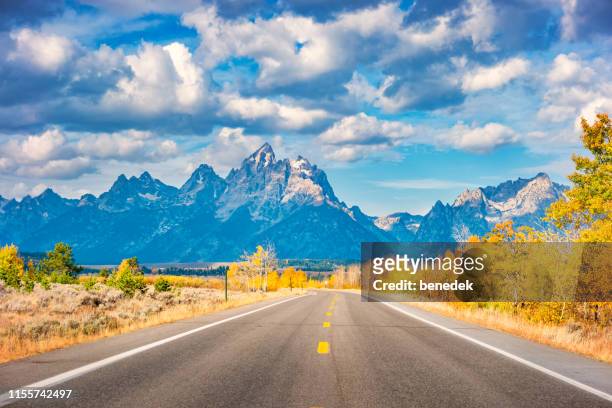 weg in grand teton national park wyoming usa tijdens de herfst - rocky mountains stockfoto's en -beelden