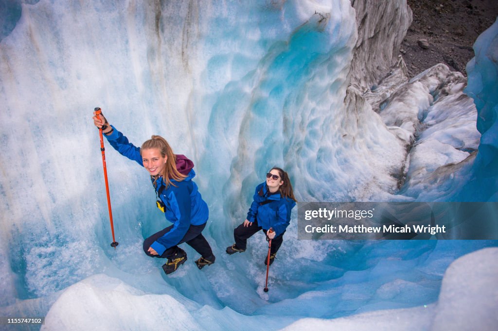 Travelers explore New Zealand's famous Franz Josef Glacier. Blue Ice, deep crevasses, caves and tunnels mark the ever changing ice.