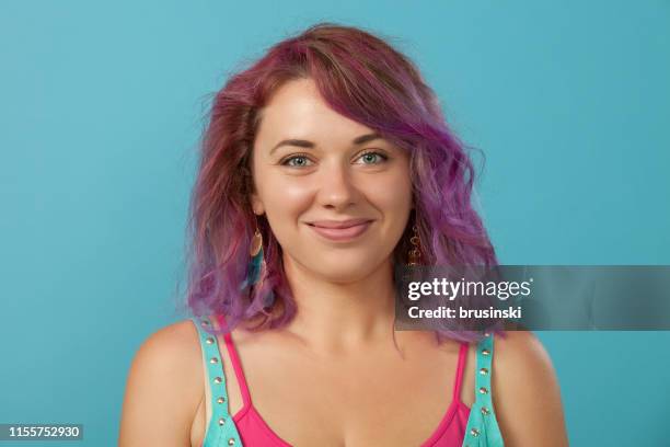 studio portrait of a 30 year old woman with purple hair on a blue background - purple hair stock pictures, royalty-free photos & images