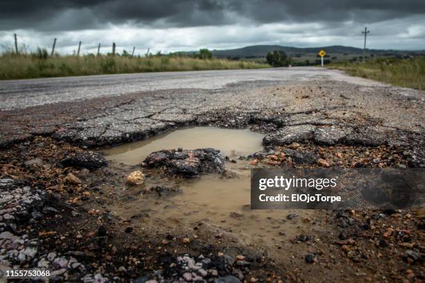 dangerous pothole, road in maldonado department, uruguay - pothole stockfoto's en -beelden