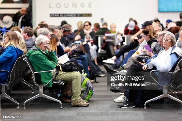 Stranded passengers wait in the departure lounge for flights to re-commence as fog blankets Auckland Airport causing delays on June 14, 2019 in...