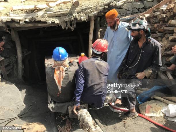 Pakistani miners take part in a search operation for their colleagues outside the collapsed mine some 35 kilometres east of Quetta, the capital of...