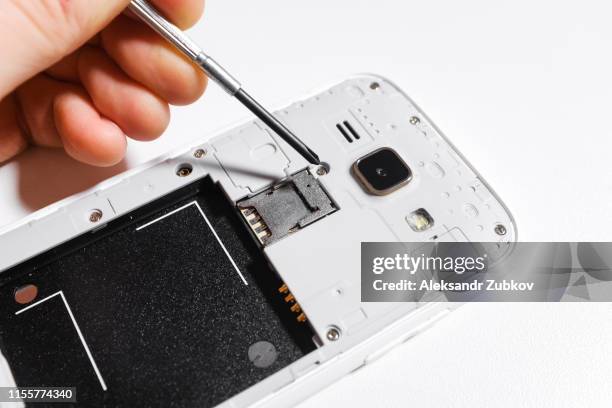 mobile phone repair, hands closeup on a white isolated background - disassemblare foto e immagini stock