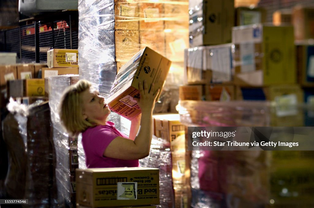 David Brewster/Star Tribune Wednesday_06/22/05_Eagan - - - - - - Denise Jorgensen searched through some of the 945 cases of Girl Scout cookies (all boxed up, addressed, and ready to go) for a half dozen that she got funds to ship.. She is looking to send