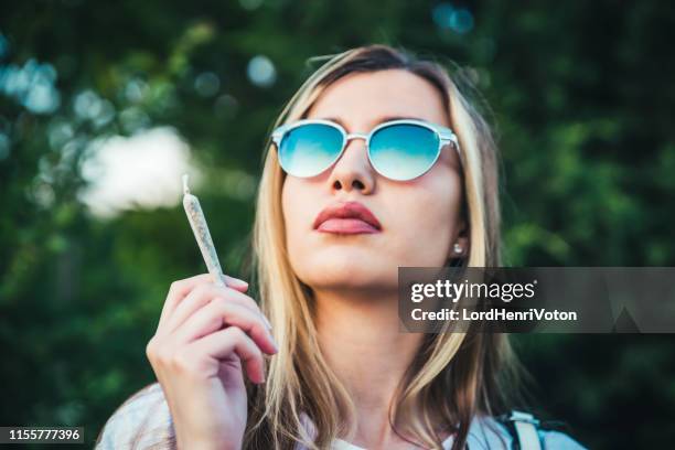 jonge vrouw met wiet gewricht - joint stockfoto's en -beelden