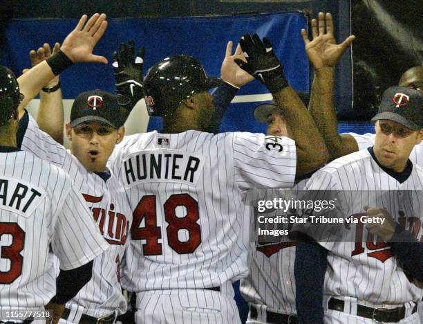 Mlevison@startribune.com 05/03/06 - Assign#102234- Twins vs. Kansas City. IN THIS PHOTO: Teammates high-five Torii Hunter at the dugout after he hit...