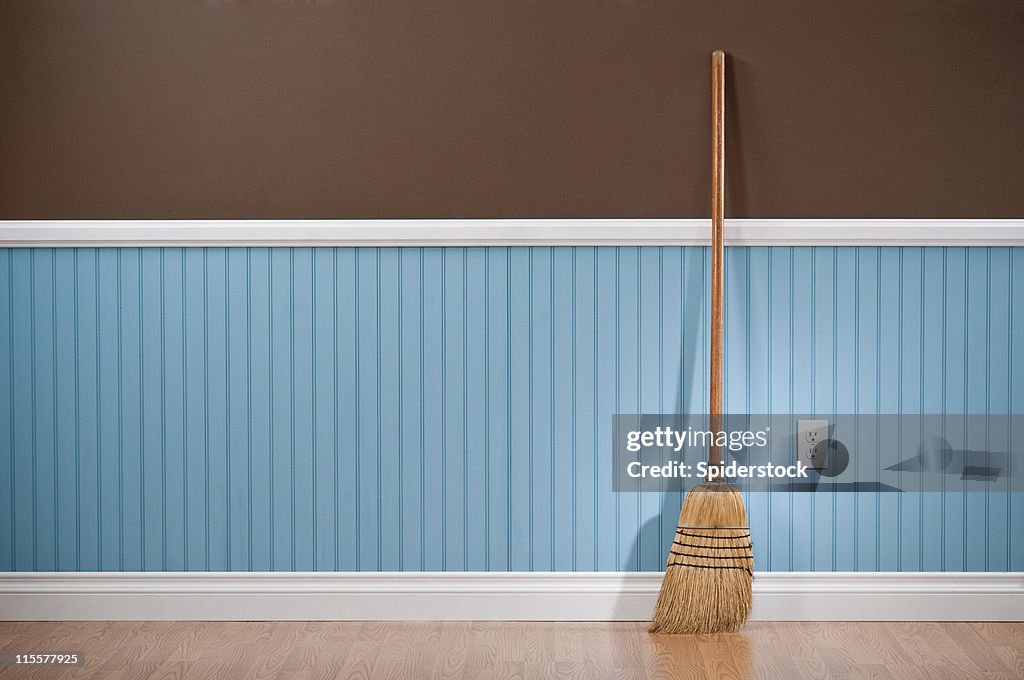 Corn whisk broom standing in empty room