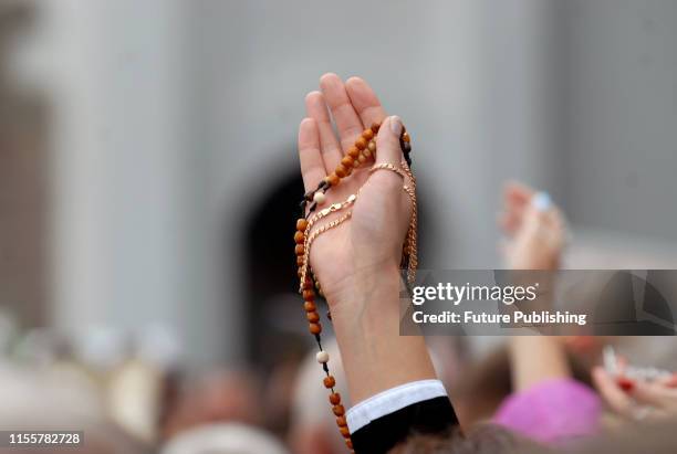 Believer holds up beads and a crucifix on a gold chain during the traditional pilgrimage of the Ukrainian Greek Catholic Church to the Zarvanytsia...