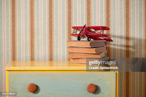 cómoda con libros en habitación vacía - bureau fotografías e imágenes de stock