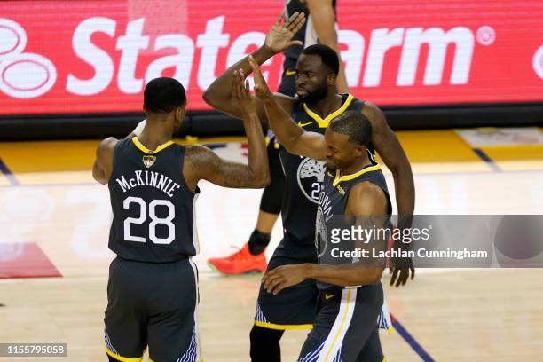 Alfonzo McKinnie, Draymond Green and Andre Iguodala of the Golden State Warriors celebrate against the Toronto Raptors in the first half during Game...