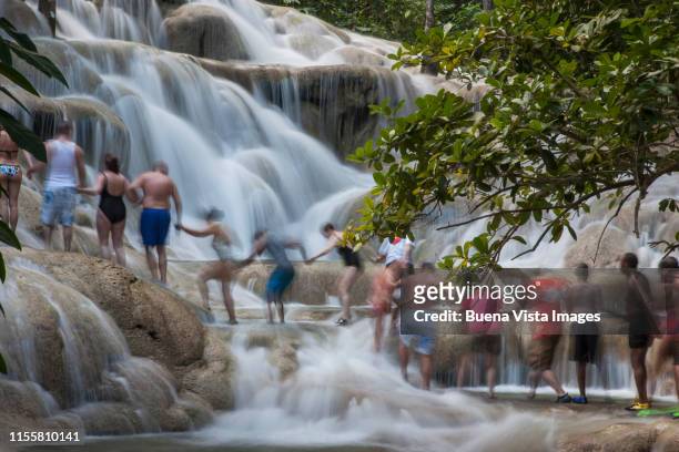people climbing a waterfall - dunns river falls stock pictures, royalty-free photos & images