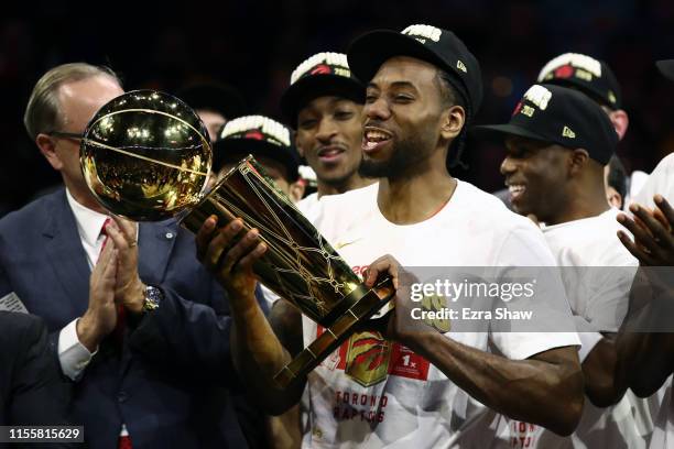 Kawhi Leonard of the Toronto Raptors celebrates with the Larry O'Brien Championship Trophy after his team defeated the Golden State Warriors to win...