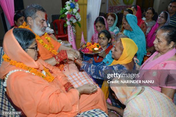 Indian Hindu devotees worship their guru Swami Chatarbhuja Acharya and his wife guru Mata Bhawna Ramanujam on the occasion of Guru Purnima at a...