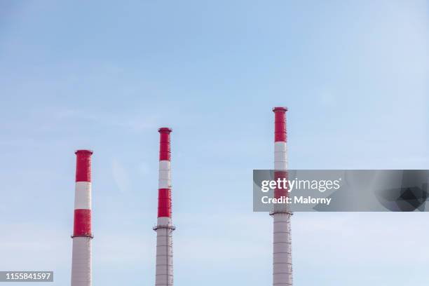 industrial chimneys against clear blue sky. - chimney stock pictures, royalty-free photos & images