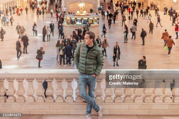 grand central station. young man waiting on his train. - grand central station manhattan stock pictures, royalty-free photos & images