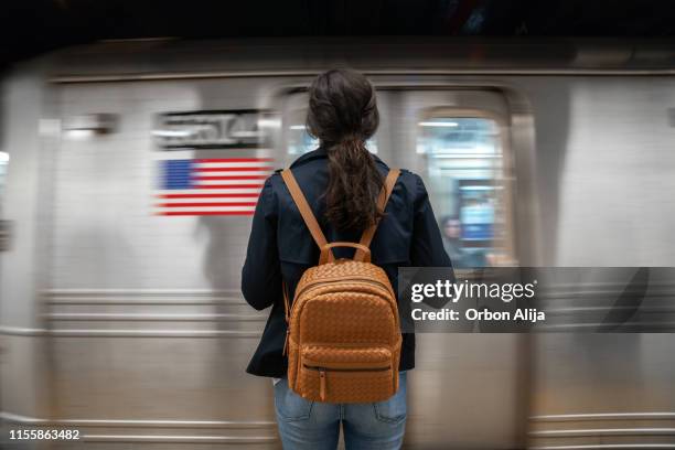 donna in attesa della metropolitana - one young woman only foto e immagini stock