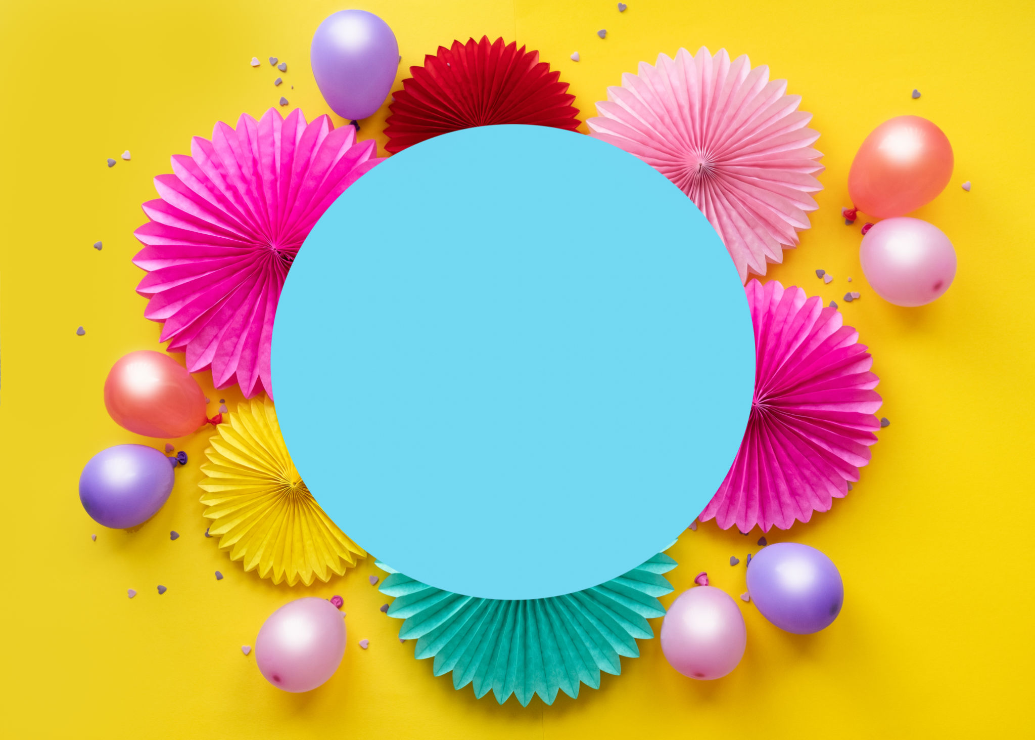 Colorful balloons and paper flowers on yellow table top view. Festive or party background. Flat lay style. Copy space for text. Birthday greeting card. Colorful balloons and paper flowers on yellow table top view. Festive or party background. Flat lay style. Copy space for text. Birthday greeting card.