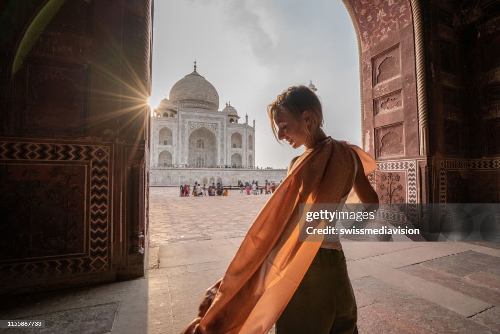 Young woman contemplating the famous Taj Mahal at sunset