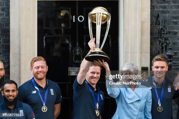 Prime Minister Theresa May and England Mens Cricket team captain Eoin Morgan lift the trophy outside 10 Downing Street ahead of the reception to...