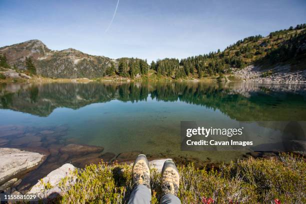 mountaineering boots in front of picturesque alpine tarn, b.c. - feet selfie woman stockfoto's en -beelden