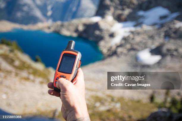 adventurer sends a safety message to loved ones at home. - garmin-global-positioning-system stock pictures, royalty-free photos & images