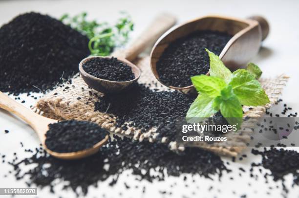 black cumin seeds background - nigella stock pictures, royalty-free photos & images
