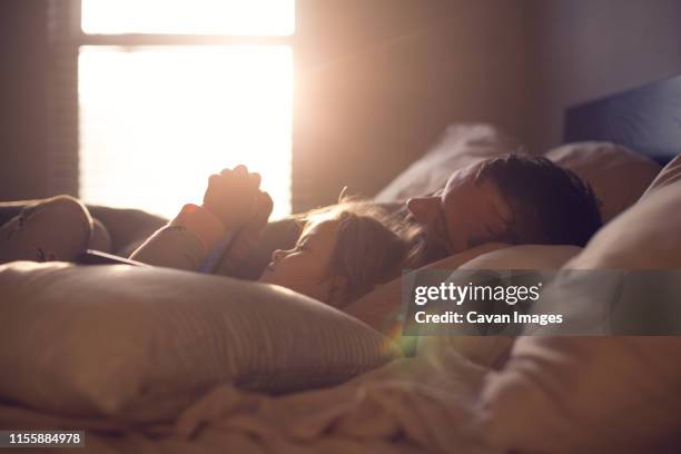 parent and child share a lazy morning in beautiful, dreamy light. - lazy sunday stock pictures, royalty-free photos & images