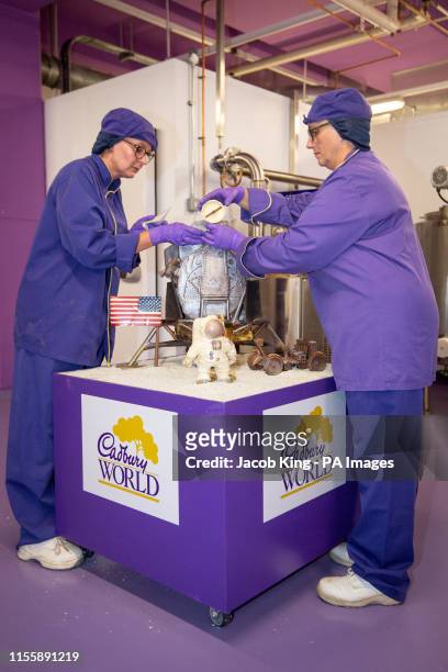 Cadbury World chocolatiers Dawn Jenks and Donna Oluban add the finishing touches to their chocolate recreation of the Apollo 11 moon landing at...