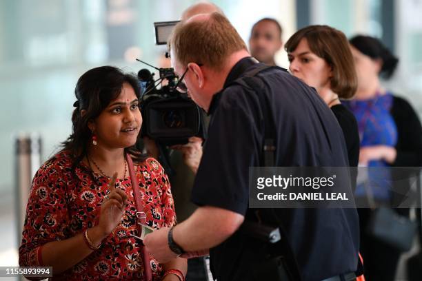 Woman is asked questions by a member of UK Border Force after landing from Bangalore in India, in Terminal 2 at Heathrow Airport in London on July 16...