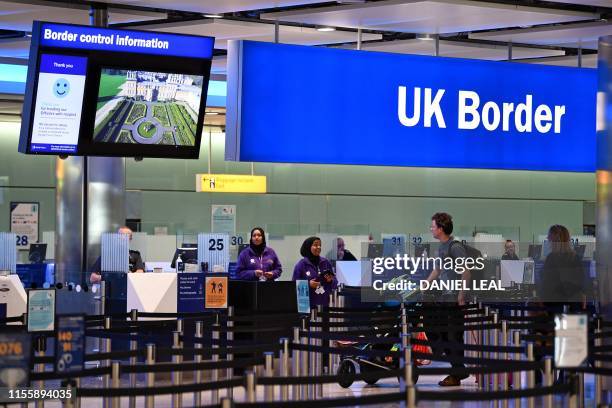 Passengers arrive at passport control in Terminal 2 at Heathrow Airport in London on July 16, 2019