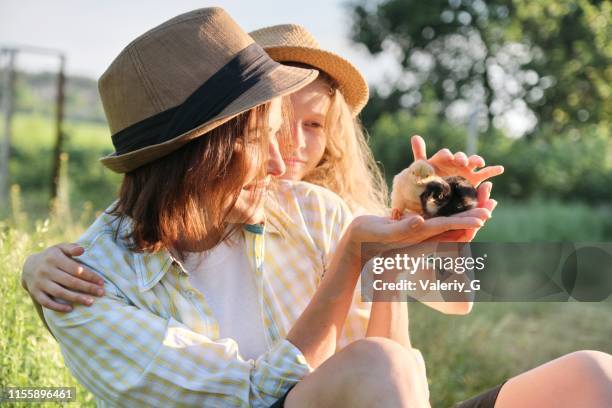 Happy family mother with daughter in nature, woman holding small newborn baby chicks in hands, farm, country rustic style