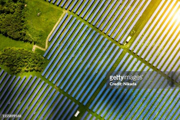 vue aérienne sur la ferme d’énergie de cellules solaires dans le paysage de campagne - champ ferme photos et images de collection