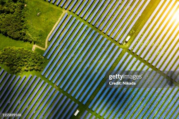 aerial view over solar cells energy farm in countryside landscape - overhead power line stock pictures, royalty-free photos & images