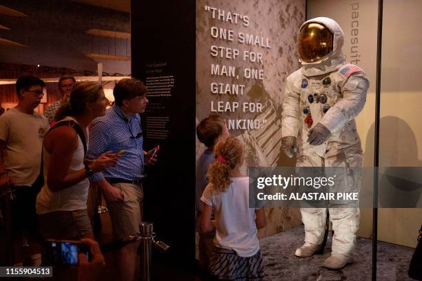 Visitors look at Neil Armstrong's Apollo 11 spacesuit after it was unveiled for the first time in thirteen years, at the Smithsonian National Air and...
