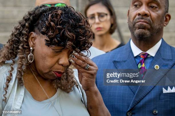 Gwen Carr, mother of the late Eric Garner, wipes away tears after speaking to the press outside the U.S. Attorney's office following a meeting with...