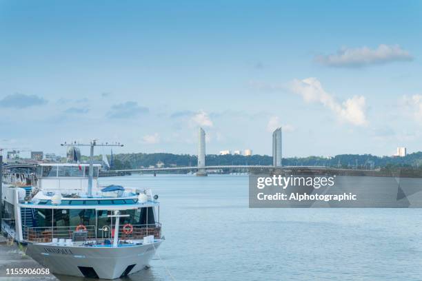 boat on the garonne river at bordeaux with the pont jacques chaban-delmas bridge - garonne stock pictures, royalty-free photos & images