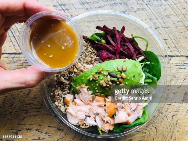 dressing a salmon, avocado and quinoa salad - vinaigrette dressing photos et images de collection