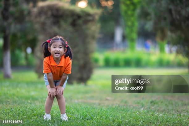 cute little girl on the lawn - hand on knee stock pictures, royalty-free photos & images