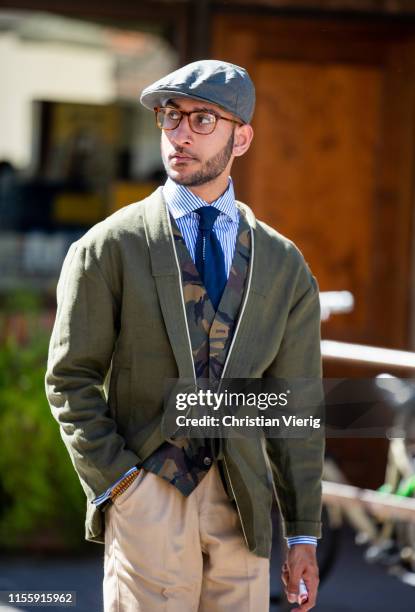 Guest is seen wearing green blazer, flat cap, beige pants during Pitti Immagine Uomo 96 on June 13, 2019 in Florence, Italy.