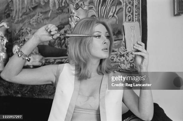 Maroccan-British actress Gabriella Licudi mimicking cutting her eyelashes with a scissor as 'Corale' in the thriller film 'The Liquidator', UK, 19th...