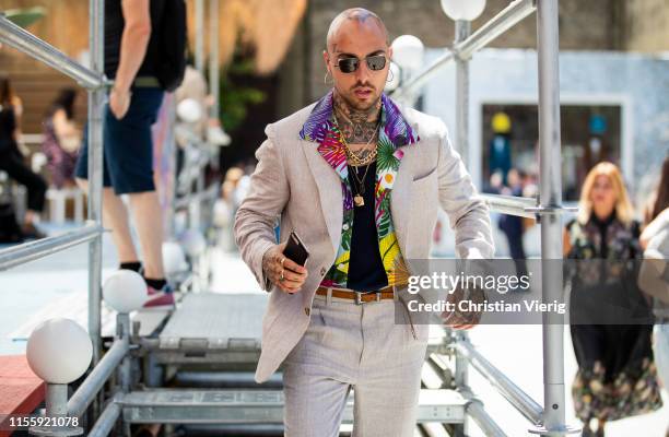 Guest is seen wearing suit, button shirt with floral print during Pitti Immagine Uomo 96 on June 13, 2019 in Florence, Italy.